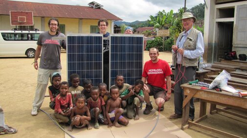 Kids in Madagascar posing with new solar panels provided by EWB-NU that were installed at their school