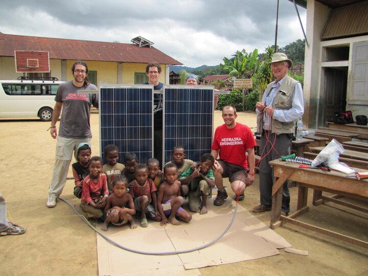 Kids in Madagascar posing with new solar panels provided by EWB-NU that were installed at their school